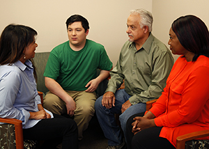 Group of two men and two women talking together.